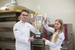 Uczniowie trzymający puchar za zajęcie pierwszego miejsca w cukierniczych zawodach Polski